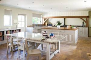 Обеденный стол выступает границей между кухней и зоной приема гостей