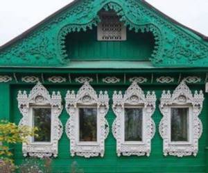 Зеленый дом с белыми наличниками