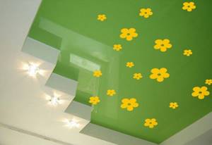 Желтые наклейки на зеленом натяжном потолке
